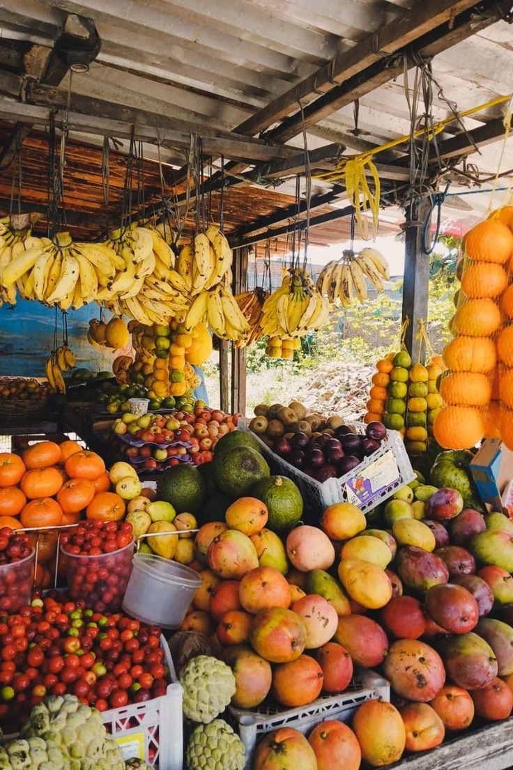 A market stall piled with bananas, papayas, mangoes and other fruit